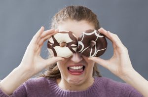 girl holding up donuts