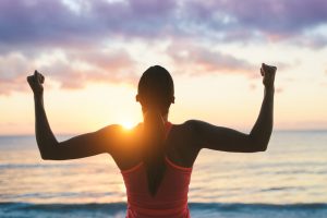 Woman celebrating fitness beach summer workout success