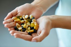 Vitamins And Supplements. Woman Hands Full Of Medication Pills