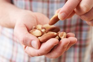 Close Up Of Man Eating Healthy Snack Of Brazil Nuts