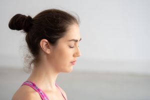 Close up of Young attractive Caucasian woman closed eyes doing meditating with mindfulness