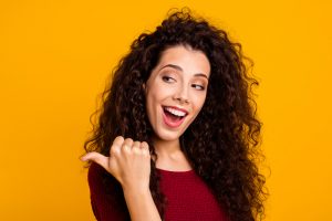 Close up photo cheerful amazing her she lady showing way one arm thumb wealth of hair on shoulders chic wearing red knitted sweater pullover clothes outfit isolated yellow background