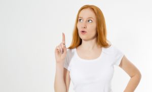 Photo wow red hair lady isolated on white background pointing her finger in eureka sign, having great innovative idea, understanding or solution she has just got. Copy space.