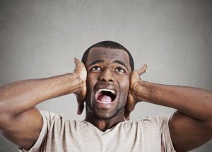 stressed man squeezing his head, going nuts, screaming