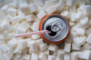 Carbonated soda drink with many sugar cubes. Unhealthy eating co