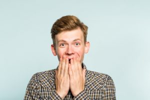 joyful excited happy man covering mouth emotion