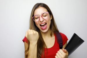 Portrait of excited smiling female student celebrating success i